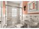 Well-lit bathroom featuring a shower with glass door, a toilet, and a pedestal sink at 6935 Date Palm S Ave, St Petersburg, FL 33707