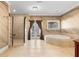 Well-lit bathroom featuring a large tub, glass-enclosed shower, and direct access to the backyard at 6935 Date Palm S Ave, St Petersburg, FL 33707