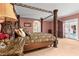 A main bedroom features an ornate four-poster bed, a patterned carpet, and access to an outside pool area at 6935 Date Palm S Ave, St Petersburg, FL 33707