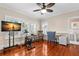 Bright bedroom featuring wood floors, ceiling fan, rocking chair, desk, exercise bike and access to an en-suite bathroom at 6935 Date Palm S Ave, St Petersburg, FL 33707