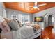 This bright bedroom features a natural wood ceiling, plush bed, and a tv at 6935 Date Palm S Ave, St Petersburg, FL 33707