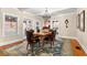Elegant dining room showcasing hardwood floors, a decorative rug, and an ornate chandelier above a wood table at 6935 Date Palm S Ave, St Petersburg, FL 33707