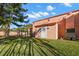 Exterior view of peach home with tile roofing, a white door, and a well-maintained lawn at 6935 Date Palm S Ave, St Petersburg, FL 33707