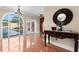 Elegant foyer with arched window view of pool, decorative mirror and table, and tile flooring at 6935 Date Palm S Ave, St Petersburg, FL 33707
