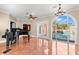 Bright foyer showcases terracotta tile, black grand piano, and arched window with a view of the pool area at 6935 Date Palm S Ave, St Petersburg, FL 33707
