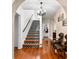 Elegant foyer featuring an archway, decorative staircase, wood floors and stylish lighting at 6935 Date Palm S Ave, St Petersburg, FL 33707