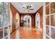 Inviting hallway with terracotta tile and wood-paneled walls leading to rooms with abundant natural light at 6935 Date Palm S Ave, St Petersburg, FL 33707