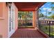 Charming outdoor patio with wooden deck, railing, and a view of the yard and screened-in pool at 6935 Date Palm S Ave, St Petersburg, FL 33707