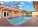 Inviting outdoor pool area with brick surround, covered seating and lush landscaping creates a private oasis at 6935 Date Palm S Ave, St Petersburg, FL 33707