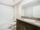 Well-lit bathroom featuring granite countertop, modern vanity, bathtub and tiled shower at 7132 Samuel Ivy Dr, Tampa, FL 33619