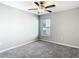 Cozy bedroom with ceiling fan, window with blinds and neutral colored walls and carpeting at 7132 Samuel Ivy Dr, Tampa, FL 33619