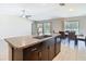 A kitchen island featuring granite countertops, a sink, and a breakfast bar, open to a dining area at 7132 Samuel Ivy Dr, Tampa, FL 33619