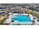 Aerial view of community pool with lounge chairs, tables, umbrellas, and surrounding landscaping and homes at 7132 Samuel Ivy Dr, Tampa, FL 33619