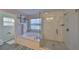 Bathroom with a soaking tub, walk-in shower with glass door, bright lighting, and tile flooring at 7325 S Trask St, Tampa, FL 33616