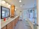 Bright bathroom with double sinks, wood cabinets, soaking tub, walk-in shower and great lighting at 7325 S Trask St, Tampa, FL 33616