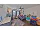 Bright bedroom featuring a ceiling fan, wood floors, window with blinds, and playful decor at 7325 S Trask St, Tampa, FL 33616