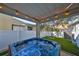 Inviting hot tub under a covered patio and string lights, creating a relaxing outdoor retreat with backyard views at 7325 S Trask St, Tampa, FL 33616