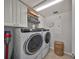 Well-lit laundry room with front-load washer and dryer, storage cabinets, and tile floors at 7325 S Trask St, Tampa, FL 33616