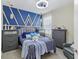 Inviting bedroom with a plush bed, coordinated gray furniture, and a striking blue accent wall, blending comfort and style at 13218 Satin Lily Dr, Riverview, FL 33579