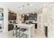 Modern kitchen featuring dark cabinets, a spacious island, pendant lighting, and stylish finishes at 13218 Satin Lily Dr, Riverview, FL 33579