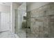 Modern bathroom featuring a glass-enclosed shower with tiled walls and floors, exuding contemporary style at 12326 Terracina Chase Ct, Tampa, FL 33625