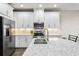 Bright kitchen featuring stainless steel appliances, white cabinetry, and beautiful quartz countertops at 12326 Terracina Chase Ct, Tampa, FL 33625