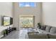 Spacious living room with a high ceiling, sliding glass doors leading to a patio, and a modern entertainment center at 12326 Terracina Chase Ct, Tampa, FL 33625