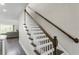 Staircase with white painted spindles and wooden handrail, with view into the living room at 12326 Terracina Chase Ct, Tampa, FL 33625