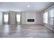 Large living room with electric fireplace, plank flooring, and large windows with flowing drapes at 13106 Zolo Springs Cir, Riverview, FL 33579