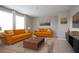 Bright living room with two orange couches, neutral color paint, modern decor and plush carpet at 13106 Zolo Springs Cir, Riverview, FL 33579