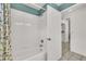 Bright white bathroom featuring white tile shower, with floral shower curtains, white door and neutral tile floors at 13216 Parkhurst Ct, Riverview, FL 33569