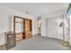 Neutral bedroom with gray carpet, white walls, closet with folding doors, wooden bookcase, and gold side table at 13216 Parkhurst Ct, Riverview, FL 33569