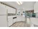 The kitchen has bright lighting, lots of white cabinets, and tile floors at 13216 Parkhurst Ct, Riverview, FL 33569