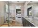 Bright bathroom featuring a walk-in shower and granite counters, with a glimpse into the bedroom at 18 Franklin S Ct # D, St Petersburg, FL 33711
