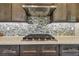 Close up on a professional gas cooktop in gourmet kitchen with attractive tile backsplash and custom cabinetry at 18 Franklin S Ct # D, St Petersburg, FL 33711