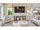 The living room is light and bright with transom windows, a large screen television and stylish decor at 18 Franklin S Ct # D, St Petersburg, FL 33711
