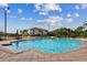 Community pool with ample seating, palm trees, and views of the surrounding neighborhood at 18 Franklin S Ct # D, St Petersburg, FL 33711