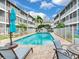 A relaxing pool view, featuring lounge chairs and a table set, surrounded by condo buildings at 521 Pinellas Bayway S # 204, St Petersburg, FL 33715