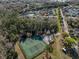 Aerial view of a community with tennis courts surrounded by lush greenery and mature trees at 5913 Lawrin Ct, Wesley Chapel, FL 33544