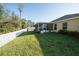 A large back yard featuring a white fence and well manicured grass at 5913 Lawrin Ct, Wesley Chapel, FL 33544