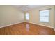 Bedroom with laminate floors, ceiling fan, and two windows offering natural light at 5913 Lawrin Ct, Wesley Chapel, FL 33544