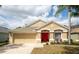 Inviting single-story home boasts a well-manicured lawn, red front door, and an attached two-car garage at 5913 Lawrin Ct, Wesley Chapel, FL 33544