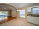 Kitchen with tile floors, white cabinets, and stainless steel appliances, plus a view of the screened lanai at 5913 Lawrin Ct, Wesley Chapel, FL 33544