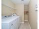 Functional laundry room with washer, dryer, shelving and tiled floors, offering convenience at 5913 Lawrin Ct, Wesley Chapel, FL 33544