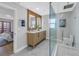 Elegant bathroom featuring a double vanity, wood accent wall, walk-in shower and linen storage at 809 59Th Ave, St Pete Beach, FL 33706