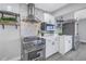 Modern kitchen with stainless steel appliances, marble backsplash, and sleek white cabinetry at 809 59Th Ave, St Pete Beach, FL 33706