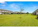 Backyard with grassy lawn and tree-lined border at 9716 Mulberry Marsh Ln, Sun City Center, FL 33573