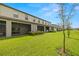 View of backyard featuring covered patio, green grass, and landscaping at 9716 Mulberry Marsh Ln, Sun City Center, FL 33573