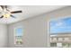 Neutral colored bedroom with ceiling fan and two windows allowing for natural light at 9716 Mulberry Marsh Ln, Sun City Center, FL 33573