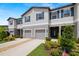 Two-story townhome featuring a driveway, attached garage, and landscaped front yard at 9716 Mulberry Marsh Ln, Sun City Center, FL 33573
